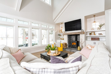 A modern farmhouse family room with transom windows and a wood burning stove.
