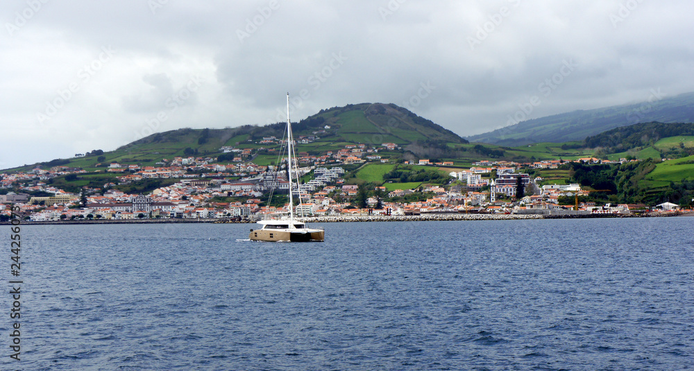 Yacht leaves the hospitable harbor of Horta.