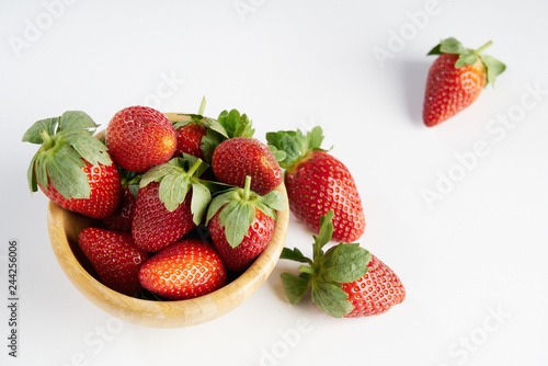 Close-up of fresh perfect berries red strawberries in a wooden plate on white  Concept of healthy eat food and nutrition..