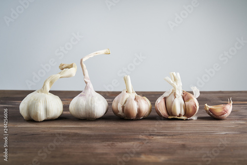 Fresh garlic on wooden background. Still life with raw vegetable. Concept of healthy food and nutrition.