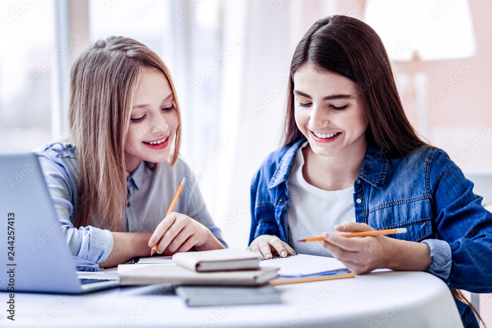 Happy merry two girls solving difficult puzzle Happy merry two girls solving difficult puzzle