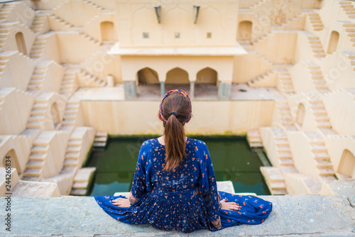 Girl sitting over Stepwell (Public place) : Landmark near Amber Fort in Jaipur, Rajasthan, India