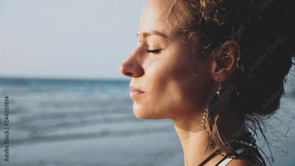 Profile portrait of young pretty woman standing on the beach