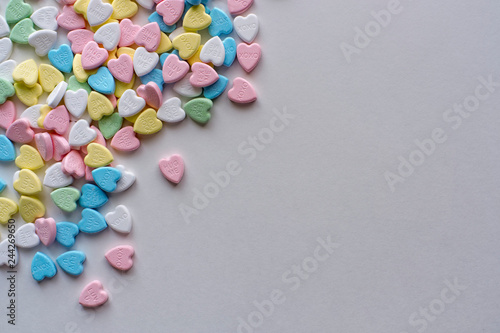 Valentine pastel colourful heart candies in a left corner pile