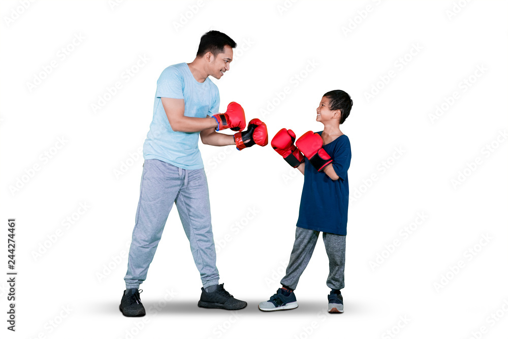 Boy doing boxing exercise with his father