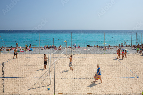 Tourists and locals playing beach volleyball at Nice beach, France
