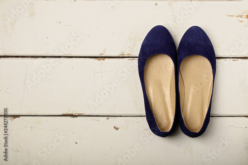 Blue women's shoes (ballerinas) on wooden background.