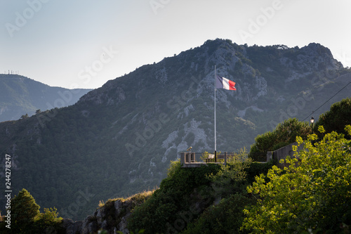 The French national flag flying over a rampart overlloking Menton, as captured from Sainte Agnes