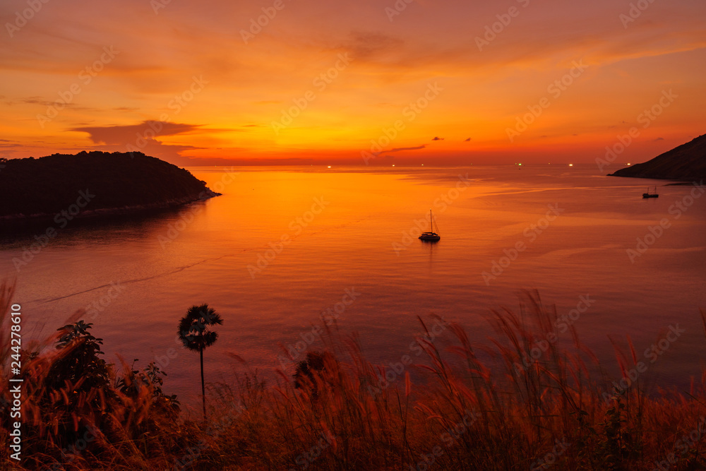 Colourful sunset over sea lagoon and sail boat on a tropical island Phuket
