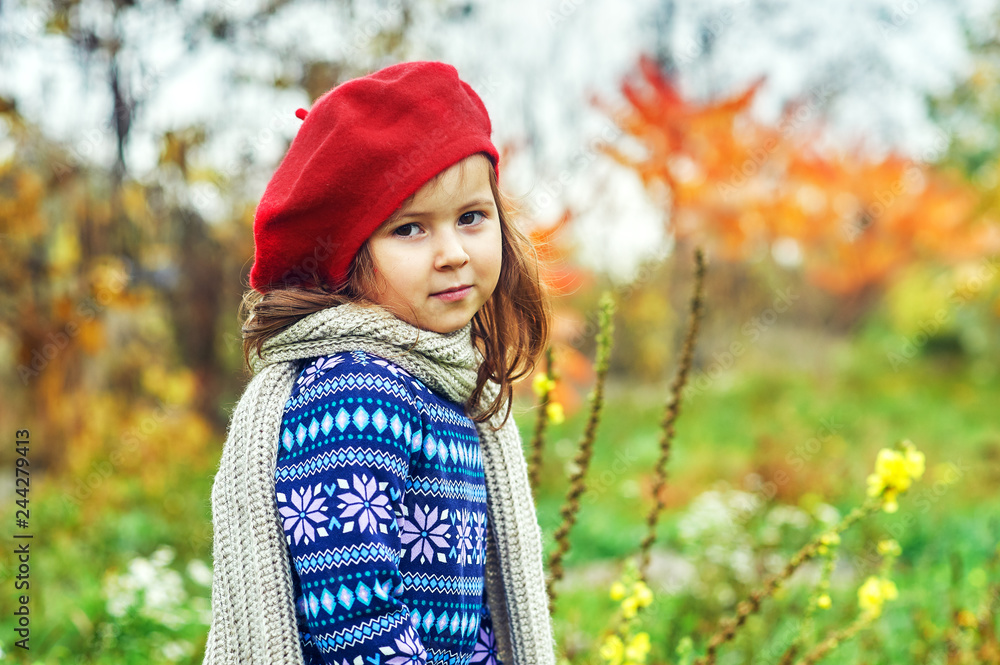 Portrait of a little girl in the fall in nature . Baby in a red beret and a warm sweater Portrait of a little girl in the fall in nature . Baby in a red beret and a warm sweater