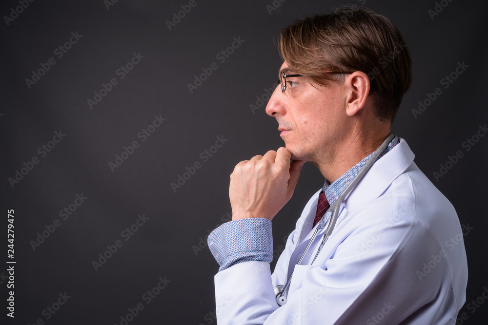 Profile view of mature handsome Italian man doctor thinking Profile view of mature handsome Italian man doctor thinking