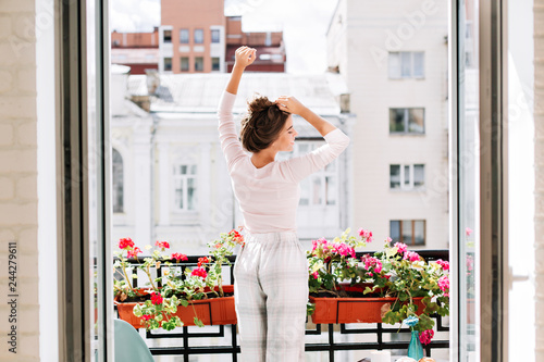 Photography Pretty girl from back in pajamas on balcony in sunny morning