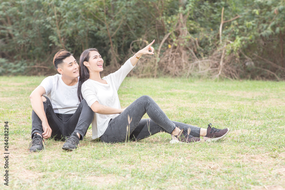 Loving young couple sitting down on grass
