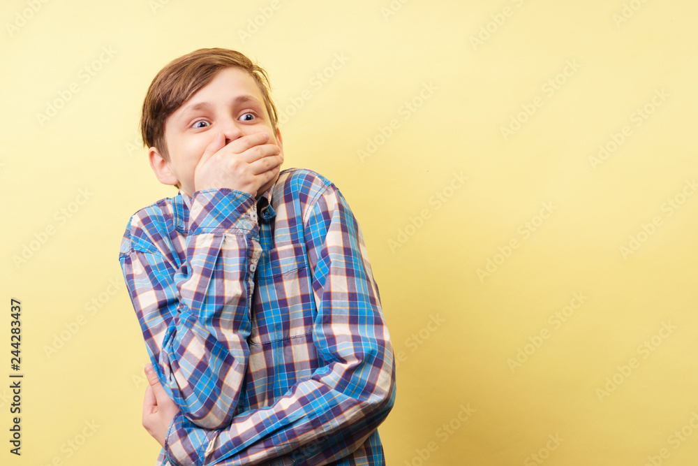 surprised shocked amazed boy clamps his mouth, gasping with astonishment looking sideways over yellow background, advertisement, banner or poster template, emotion facial expression, people reaction surprised shocked amazed boy clamps his mouth, gasping with astonishment looking sideways over yellow background, advertisement, banner or poster template, emotion facial expression, people reaction