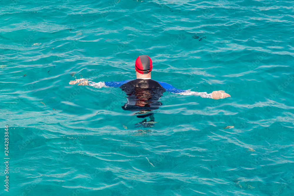 man with snorkel mask tuba and snorkel in sea. Snorkeling, swimming, vacation. Tourists are engaged in snorkeling in the open sea. Holidays in the seaside resort.