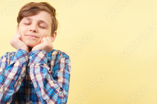 dreamy, faraway, dispelled, dissipated boy daydreaming. portrait of a wistful kid over yellow background, advertisement, banner or poster template, emotion facial expression, people reaction