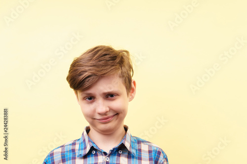 smug cheeky daring boy with skeptical smile over yellow background, advertisement, banner or poster template, emotion, people reaction