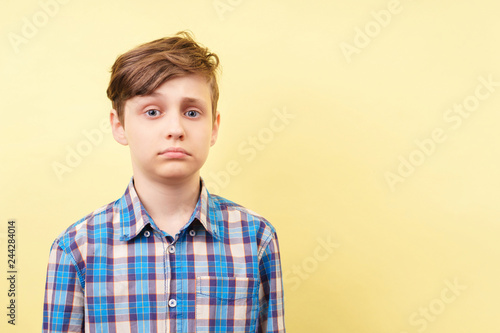 boy with disappointed face expression over yellow background, advertisement, banner or poster template, emotion, people reaction