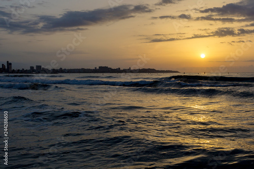 the beach against sunrise and big wave. The concept of freedom and relaxation. Reflection of the amazing sunset sky. The sky is in incredible clouds.