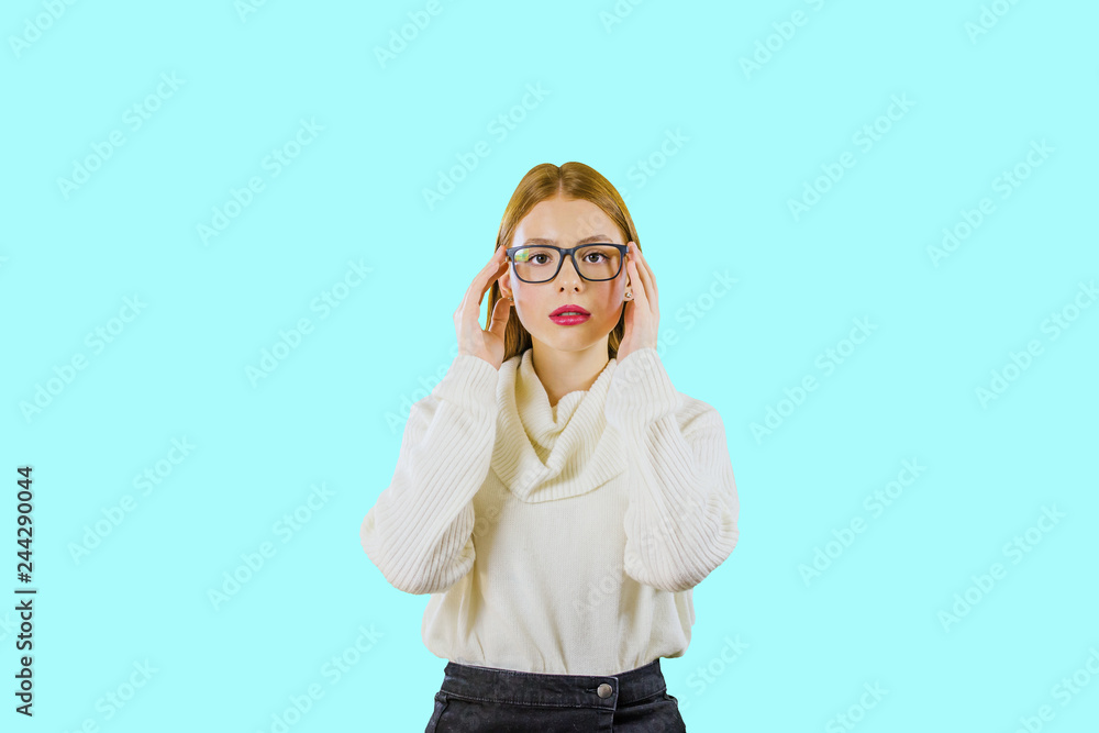 A serious girl with long red hair in glasses is looking into the camera on an isolated background A serious girl with long red hair in glasses is looking into the camera on an isolated background