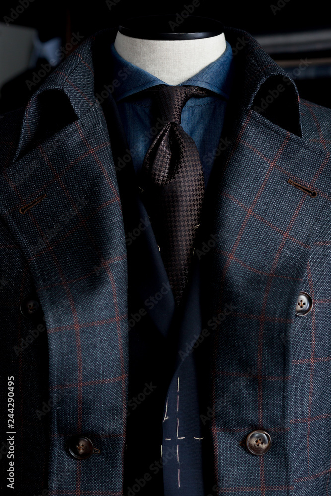 Close up of a dark bespoke coat in a cage Close up of a dark bespoke coat in a cage