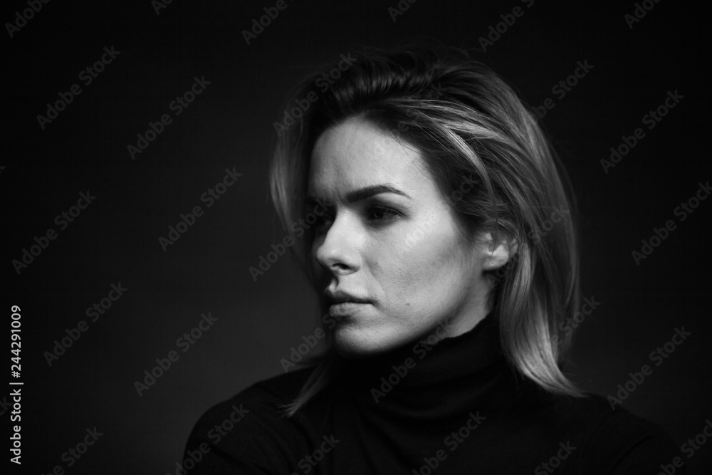 Dramatic black and white portrait of a beautiful woman on a dark background