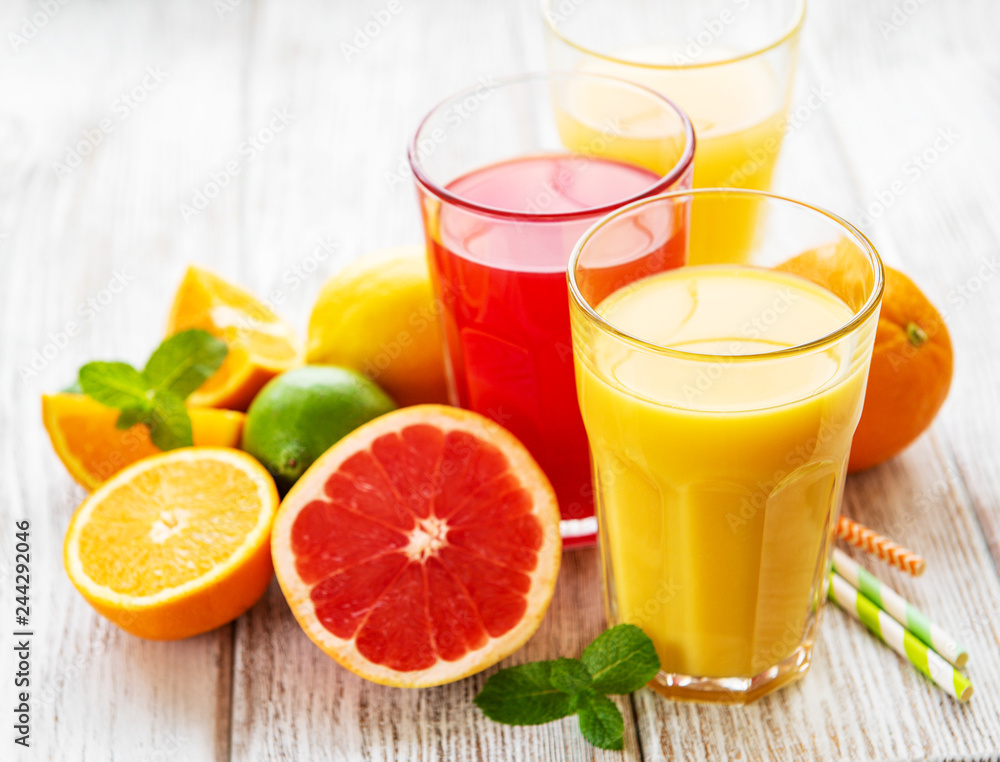 Glasses of juice and citrus fruits Glasses of juice and citrus fruits