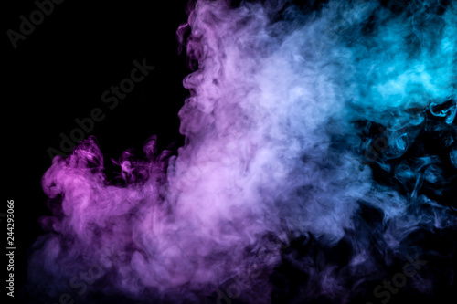 Clouds of isolated colored smoke: blue, red, green, pink; scrolling on a black background in the dark close up.