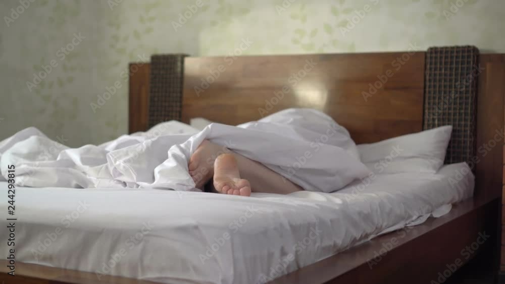 man sleeps on a bed under a duvet and opens his legs.
man sleeps on a bed under a duvet and opens his legs.