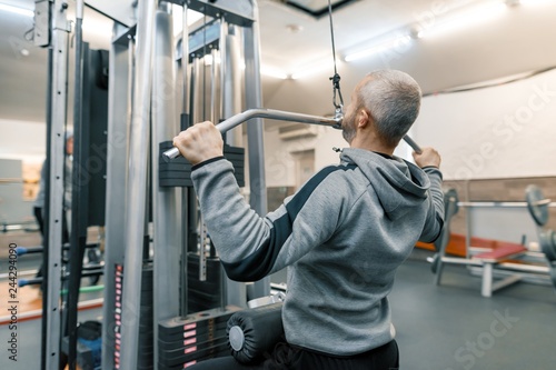 Adult age man working in training gym. Sport rehabilitation, age, healthy lifestyle concept. photo