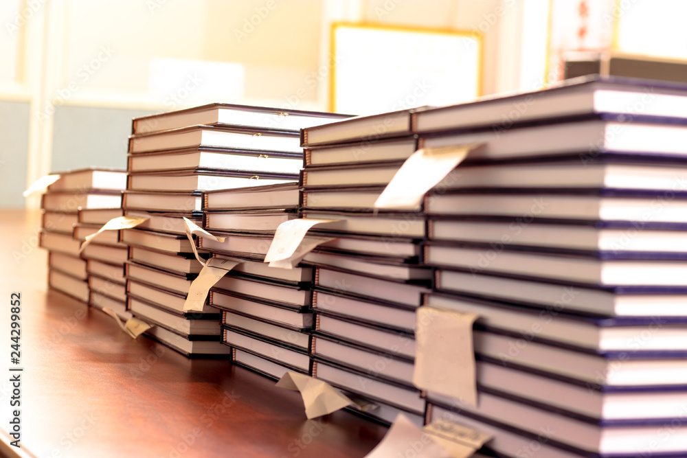 Obraz premium Pile of independent study reports are arranged on a table waiting for verification and wait for dean to sign.