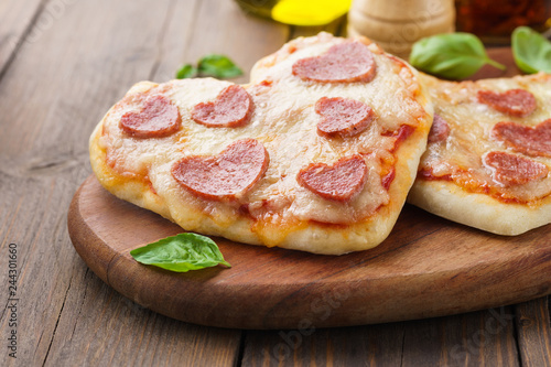 Homemade heart shaped mini pizzas with pepperoni.