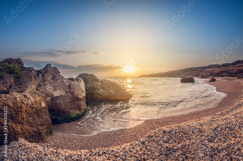 Beautiful landscape, sandy rocky bay at sunset, wild seashell beach