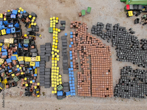 TOP DOWN: View from above of empty colorful garbage cans in a large junkyard.