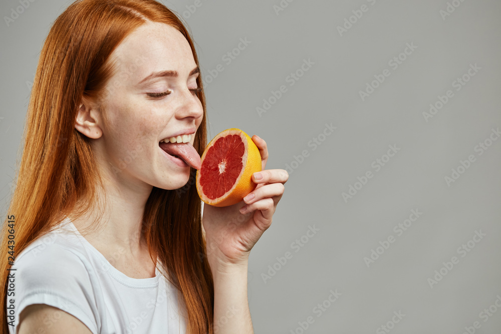 nice attractive girl licking sour grapefruit. close up photo. unusual taste ofexotic fruit nice attractive girl licking sour grapefruit. close up photo. unusual taste ofexotic fruit