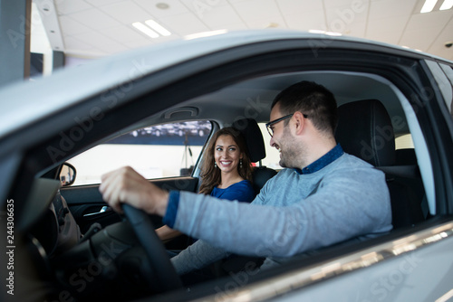 Young couple testing new vehicle they want to buy. Car dealer.