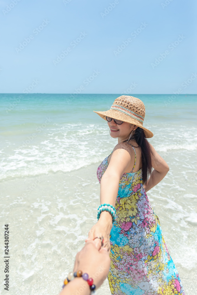 Couple summer vacation travel, Woman walking on romantic honeymoon and relax on sand beach in holidays holding hand of boyfriend following her. Summer Concept