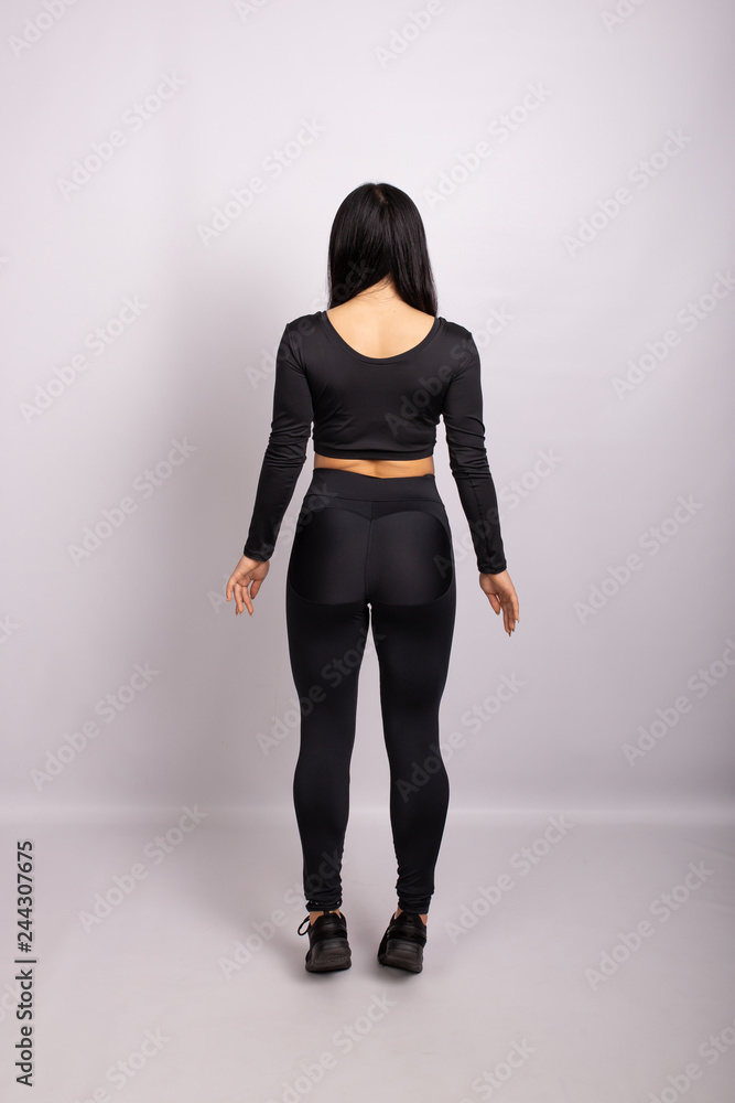 Sportive woman wearing black leggings and top. Rear view Sportive woman wearing black leggings and top. Rear view