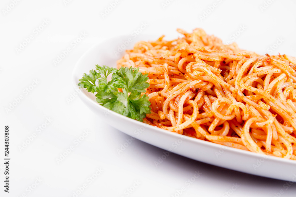 Spaghetti with pesto rosso decorated with parsley on a white background Spaghetti with pesto rosso decorated with parsley on a white background
