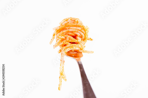 Spaghetti with pesto rosso on a fork on a white background