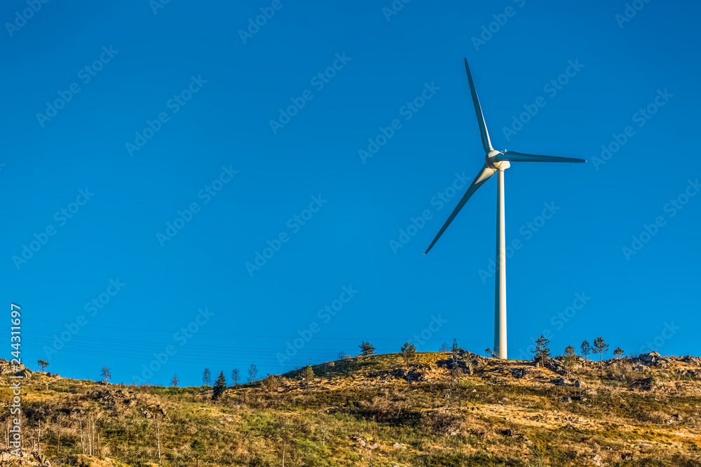 View of a wind turbine on top of mountains View of a wind turbine on top of mountains