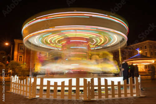 View of a spinning carousel for kids. Night scene. Long exposure.