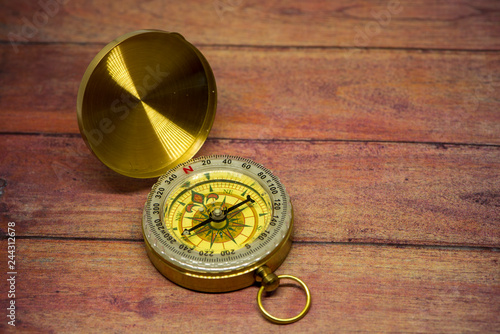 An old compass on a wooden table