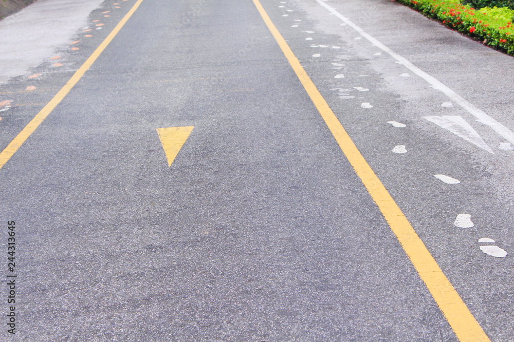 Asphalt road with two yellow lines and  sidewalk mark abstract on background