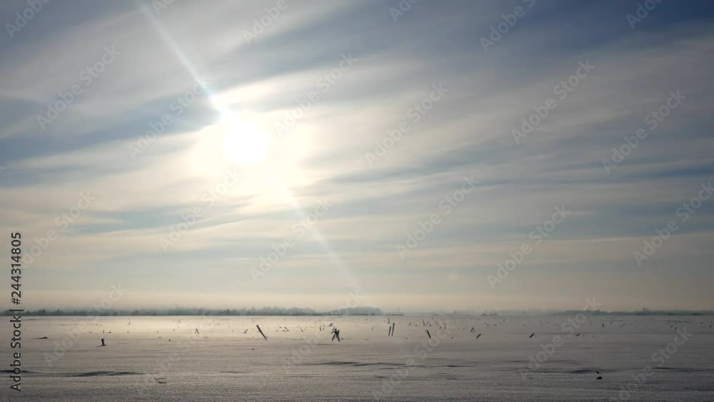 Winter field covered with snow with traces on the snow. Sunset in landscape the winter Winter field covered with snow with traces on the snow. Sunset in landscape the winter