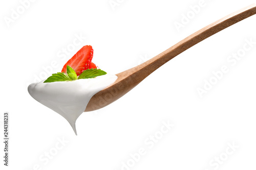 Plain yogurt on a spoon with fresh strawberry on top isolated on white background