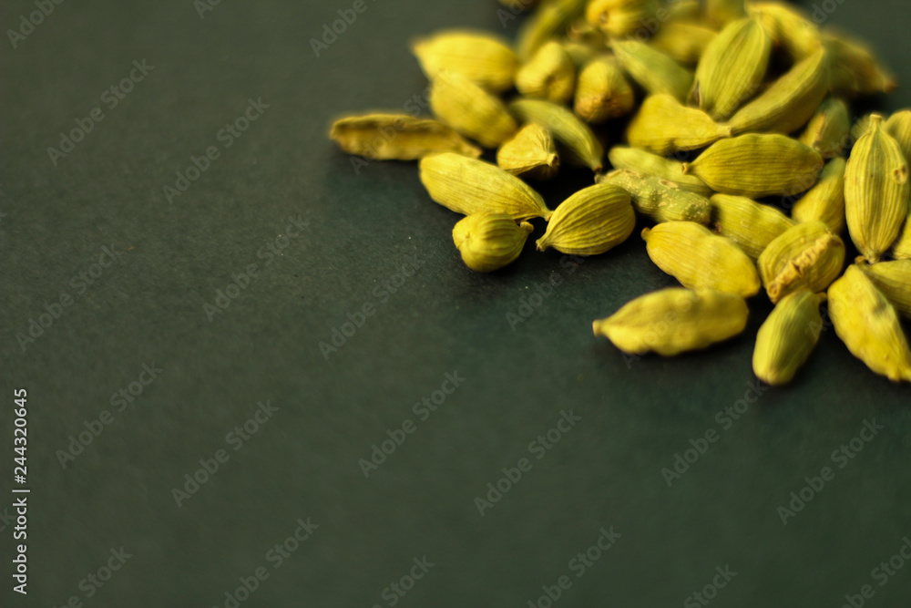 Close up on green cardamon seeds, selective focus, dark green background, selective focus Close up on green cardamon seeds, selective focus, dark green background, selective focus