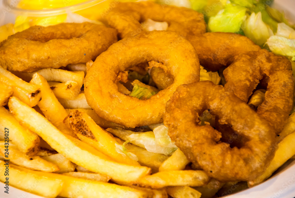 Roman squid with chips served on a plate. Roman squid with chips served on a plate.