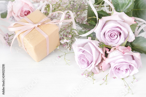 Fototapeta Naklejka Na Ścianę i Meble -  Kleines Geschenk und Rosen zum Valentinstag, Muttertag, Hochzeitstag, Jahrestag oder Geburtstag