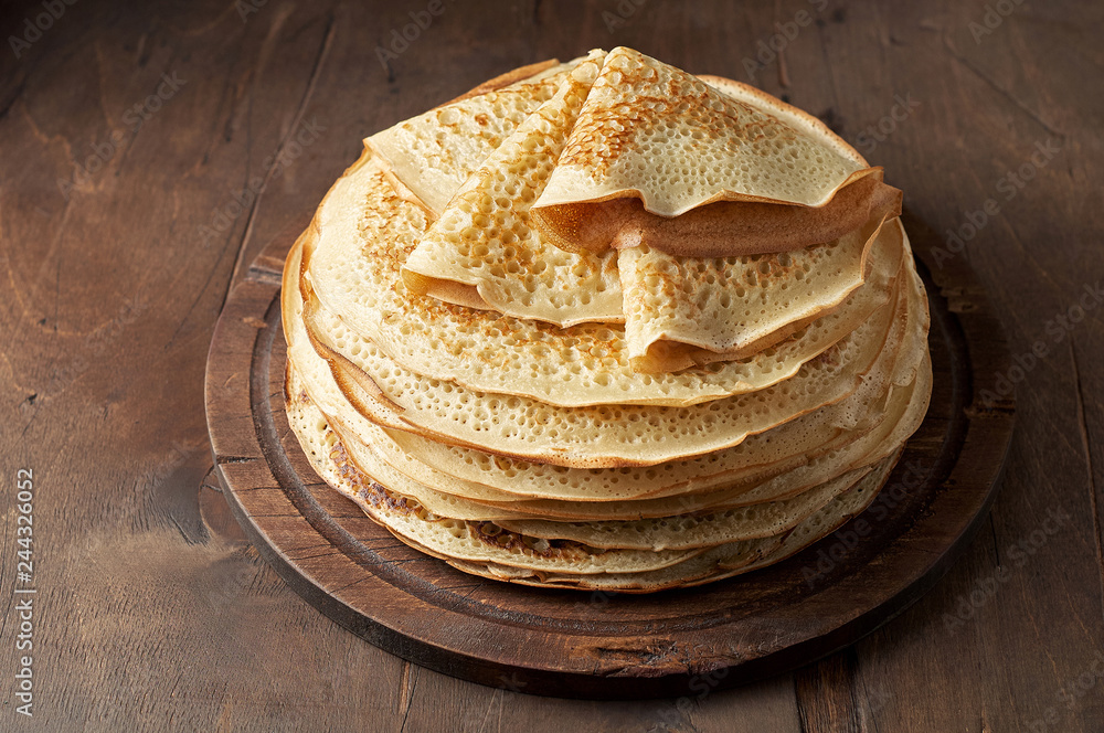 Stack of russian pancake blini on a wooden background